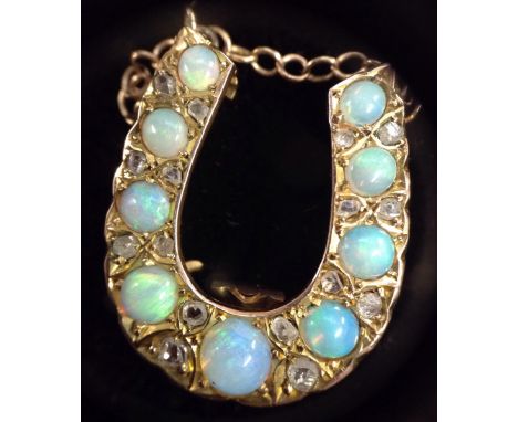 An Edwardian opal and diamond horse shoe pendant necklace, the nine graduated round opal cabochon's, each separated by a pair