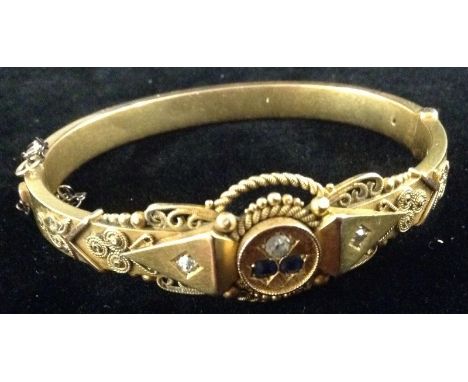An Edwardian Aesthetic Movement diamond and sapphire hinge bangle, central round panel set with a pair of deep blue round sap