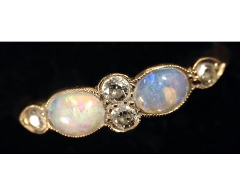 A six stone opal and diamond ring, two round brilliant cut diamonds, flanked by two oval cabochon opals, flashing green, blue