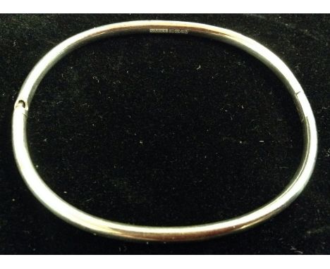 A Symbol 9ct white gold hinge bangle, rounded hollow body, invisible secret clasp, 6cm diameter, Birmingham 2005, 16.5g gross