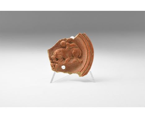 1st-2nd century AD. A fragment of a ceramic oil lamp with chamfered rim, high-relief image of a lion(?) attended by two winge