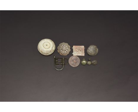 15th-18th century AD. A mixed group comprising: a swivel buckle; a small container with domed screw lid; a square plaque with