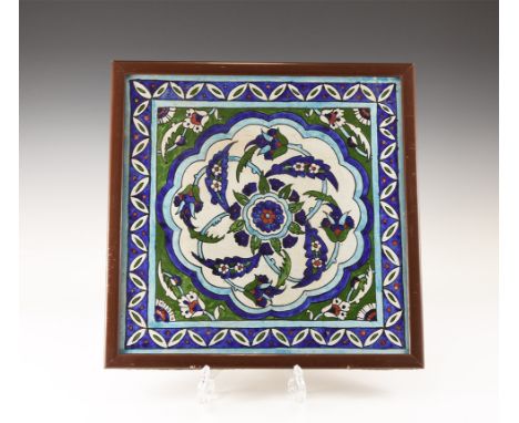 20th century AD. A glazed ceramic tile with central rosette, radiating flowers and tendrils, in a blue border with petals and
