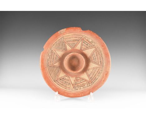 1st millennium BC or later. A broad burnished ceramic platter with basal ring and central socket, hatched painted detailing. 