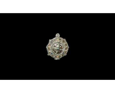 2nd century AD. A disc brooch with convex centre, enamelled panels, radiating peripheral lugs, remains of hinged pin and catc