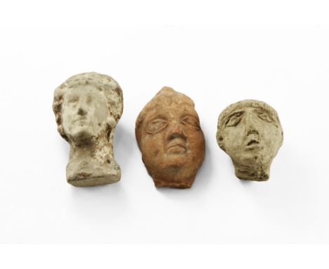 4th-2nd century BC. A group of three ceramic heads consisting of a male youth with cap of hair; a female with centre parted h