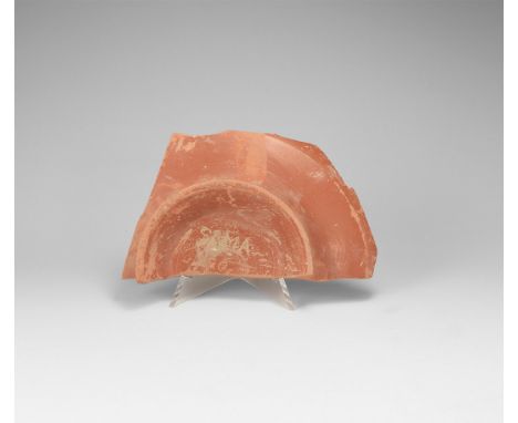 1st-3rd century AD. A fragment of red-slip ceramic dish with flared base, sgraffito text to the underside 'SIMA' personal nam