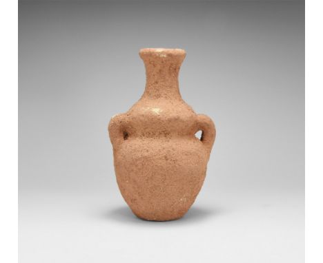 3rd millennium BC. A small ceramic vase with gusset to the shoulder, slender spout and rolled rim, two lateral loop handles. 