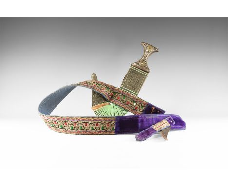 20th century AD. A dagger and sheath on a decorative belt comprising: a curved jambiya dagger with midrib to the blade, waist