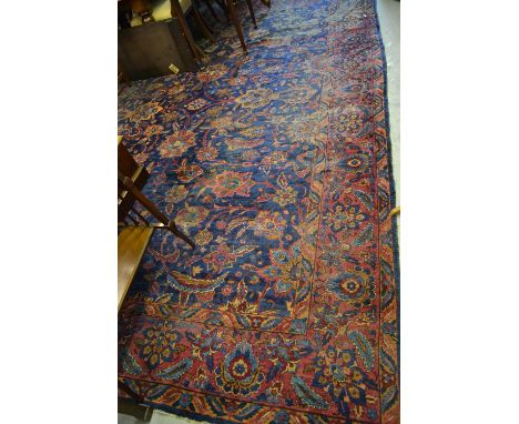 Meshed carpet having all-over floral design on a blue and burgundy ground with borders, 13ft x 9ft approximately (worn) CONDI