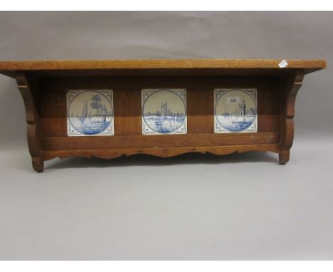 Group of three blue and white Delft tiles mounted in an oak shelf