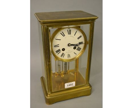 Late 19th Century brass four glass library clock with enamel dial, Roman numerals and two train movement, the dial signed Neg