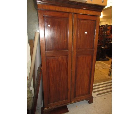 Edwardian mahogany wardrobe in George III style with a moulded cornice above two panel doors, raised on bracket feet CONDITIO