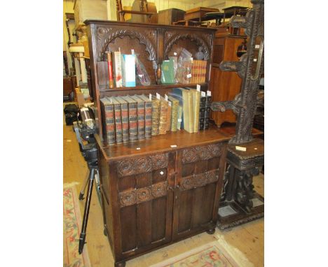 Small reproduction oak dresser with a boarded shelf back above two carved and panelled doors, 36.5ins wide