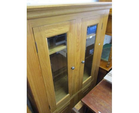 Reproduction light oak side cabinet with two glazed doors above two cupboard doors