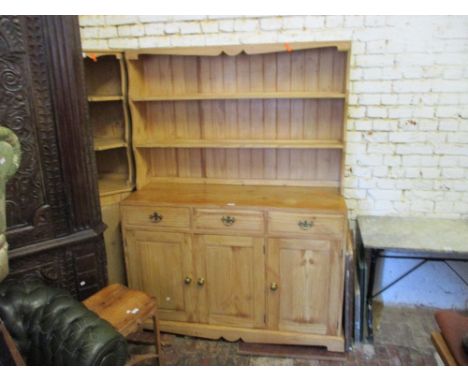 Stripped pine dresser with a boarded shelf back above three drawers and three cupboard doors together with a matching standin