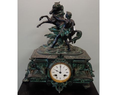 A 19TH CENTURY SPELTER MANTEL CLOCK decorated with a study of a horse with a figure, 41cm high