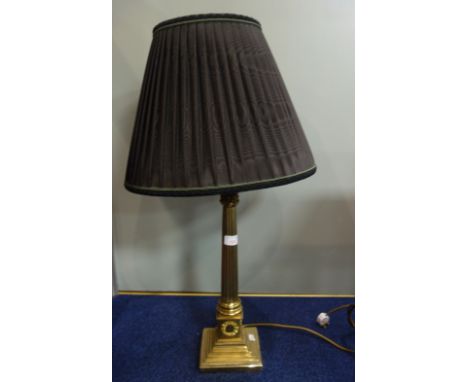 A BRASS CORINTHIAN COLUMN ELECTRIC TABLE LAMP with a pleated shade, (46cm high plus fitting)