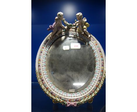 A CONTINENTAL CERAMIC EASEL MIRROR, decorated with cherubs, 33.5cm high