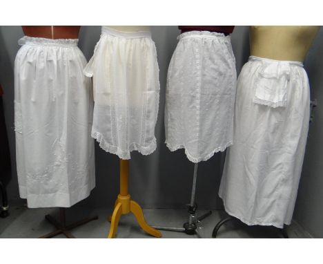 Collection of antique late 19th/early 20th Century cotton aprons with embroidery and lace detail, together with an embroidere