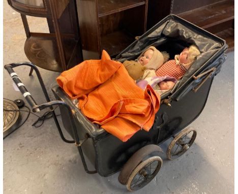 Vintage child's toy pram, the interior revealing three dolls and a vintage teddy bear in distressed condition.   (B.P. 21% + 