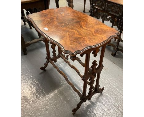 Unusual gothic design walnut lamp table, the moulded and shaped top above drop finials with double central stretcher on caste