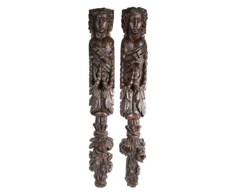 A large and impressive pair of 17th century oak figural terms  Each carved as a female, with elongated face, curly hair, tors