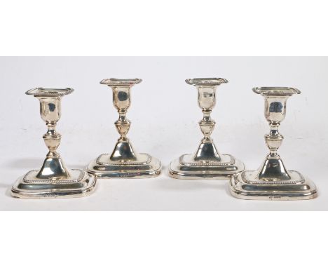 A set of four George V silver candlesticks, Sheffield 1918, maker William Hutton &amp; Sons Ltd. the detachable rectangular g