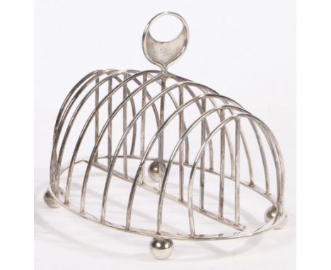 A George III silver toast rack, London 1811, maker Samuel Hennell, the pierced crescent form carrying handle with ramapnt lio