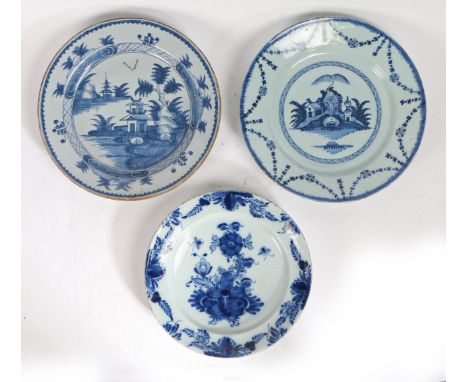 A collection of three 18th century Delft chargers  The first designed with a central flower sprig and flower edge, 31cm diame