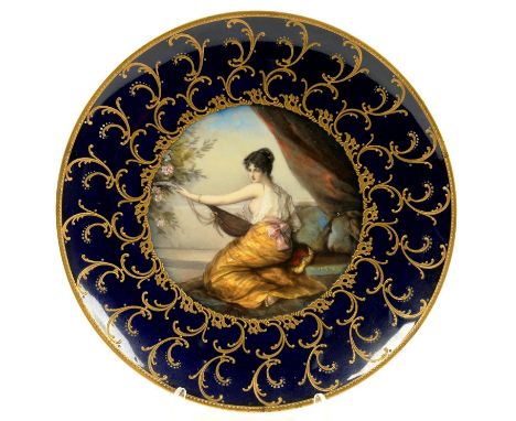 A CONTINENTAL PORCELAIN COBALT GROUND CABINET PLATE, PAINTED WITH A SEMI NAKED SEATED WOMAN PLAYING THE LUTE, IN RAISED GILT 