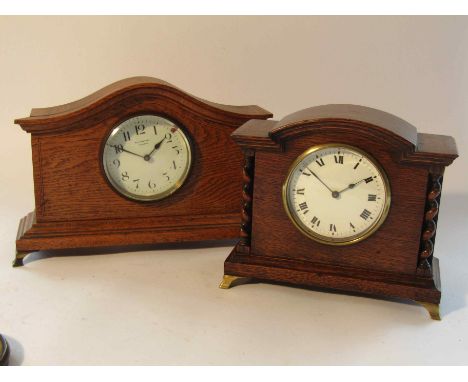Two Edwardian oak timepieces of architectural form with enamelled Arabis and Roman dials, French drum movements with latform 