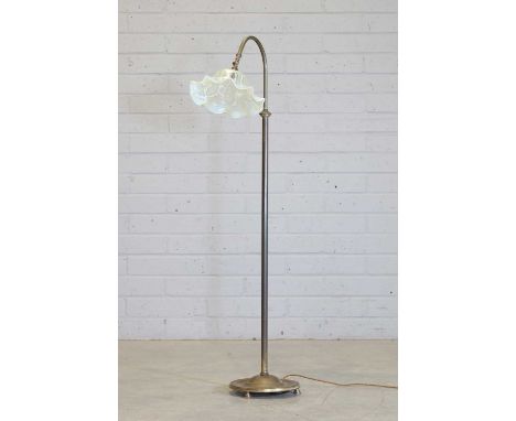 A straw opalescent glass standard lamp, late 19th century, with a relief moulded shade, suspended on a brass stem, on a brass