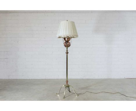 A WAS Benson copper and brass standard lamp, converted from an oil lamp, with a pleated shade, raised on paw feet, stamped to
