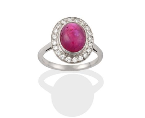 A Ruby and Diamond Cluster Ring, the cabochon ruby in a white rubbed over setting, within a border of eight-cut diamonds in c