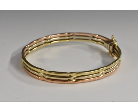 A 9ct gold tri colour open cast hinge bangle, twin safety loops, stamped 375, 12mm wide , 66mm diameter,14.6g gross