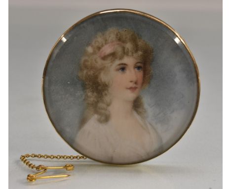 A late 19th century portrait brooch, elegant young lady, yellow metal mount, safety chain