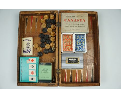 A late 19th / early 20th Century tooled leather covered book-form chess and backgammon board together with draughts pieces an