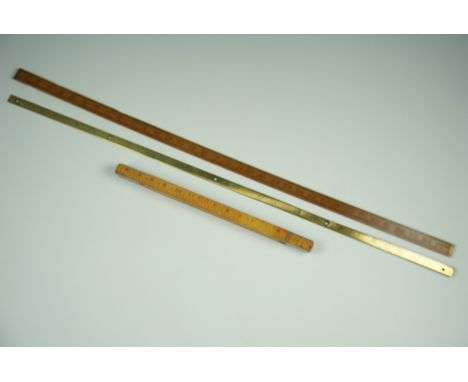 A brass yard stick, one other and a "Fisco" ruler 