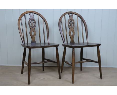 A pair of Ercol wheel back dining chairs, with Prince of Wales feathers in backsplat roundel, kite mark stamp to underside of