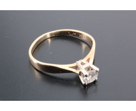 A diamond solitaire ring, comprising a brilliant cut stone of approximately 0.15 ct cathedral set on a 14 K yellow metal shan