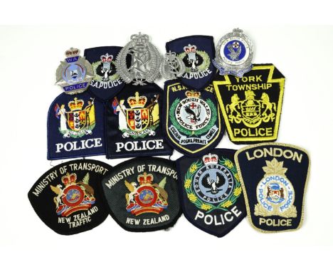 A quantity of antipodean police items, comprising New Zealand police cap and helmet badges, Australian Police enamelled badge
