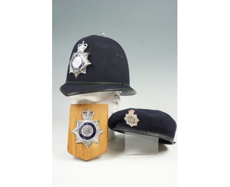 A QEII Ministry of Defence Police helmet, together with a related beret, and a helmet plate mounted onto a wooden plaque