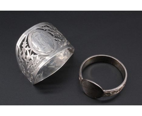 Two silver napkin rings, comprising Celtic strap-work band and a vacant round cartouche, Birmingham 1976, and pierced with a 