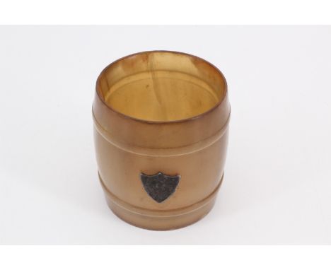 A 1920s glass-bottomed horn barrel-form dram beaker, having an applied silver shield-shaped plaque, 5 cm