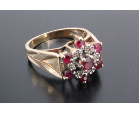 A vintage ruby and white stone cluster ring, comprising a central facet-cut ruby claw-set within a ring of smaller white ston