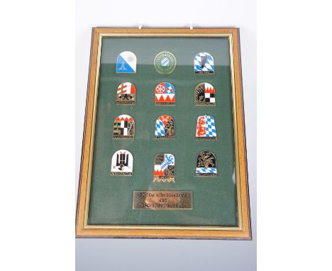 A collection of German police memorabilia, comprising displays of badges, a novelty money box as a police motorcycle helmet, 