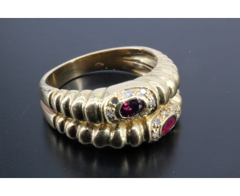 A contemporary ruby and diamond double hoop ring, the oval stones of approximately 3 mm x 4 mm, bezel set within frames of sm