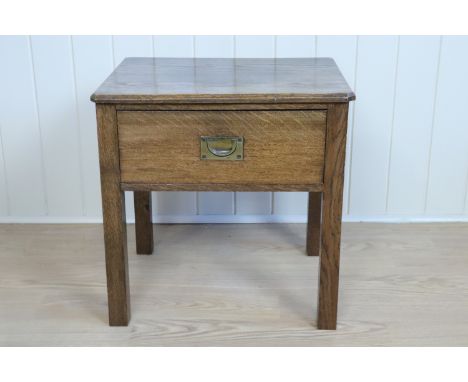 An Edwardian oak lamp or low table with single drawer, having a campaign style inset brass handle, 47 x 38 x 47.5 cm
