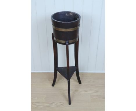 An early 20th Century brass banded coopered oak  jardiniere, on a three legged stand with triangular lower shelf, planter 26.